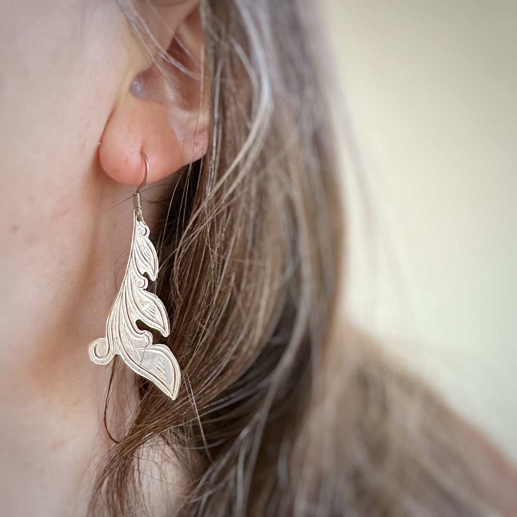 Silver earrings handcut from vintage silverplate in a leafy flourish engraved design. The french hook style ear wires are 304 grade surgical steel. Shown on model.