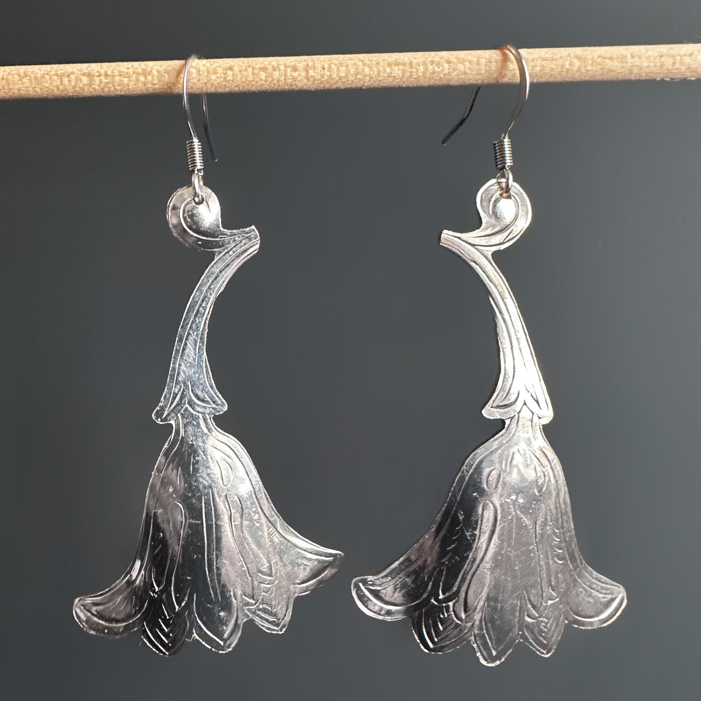 Large silver earrings in a trumpet-like shaped flower with engraved details. Surgical steel french hook style ear wires.