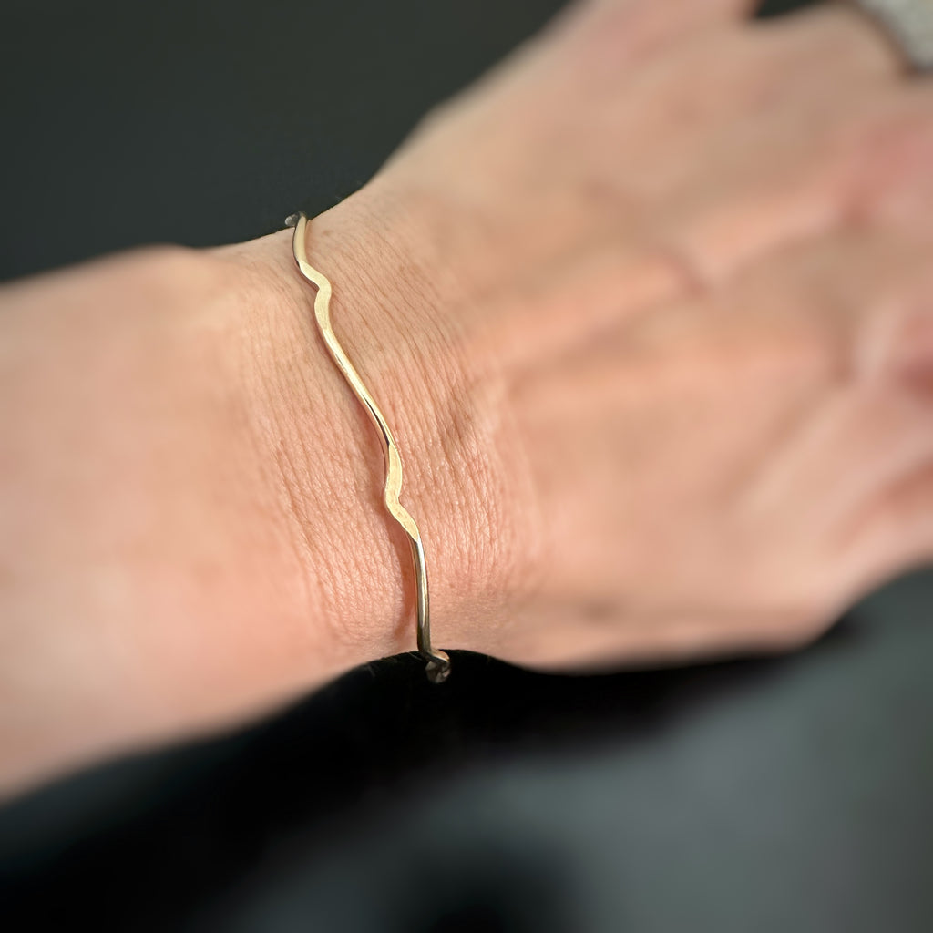 curly 14k gold-filled bracket parenthesis bangle bracelet on model.