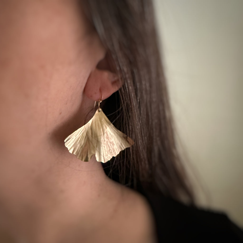 Extra large 14k gold filled ginkgo leaf earrings shown on model.