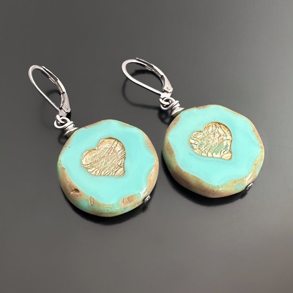 lever-back style earrings with turquoise color glass coin shaped beads with crackled golden hearts in the center.