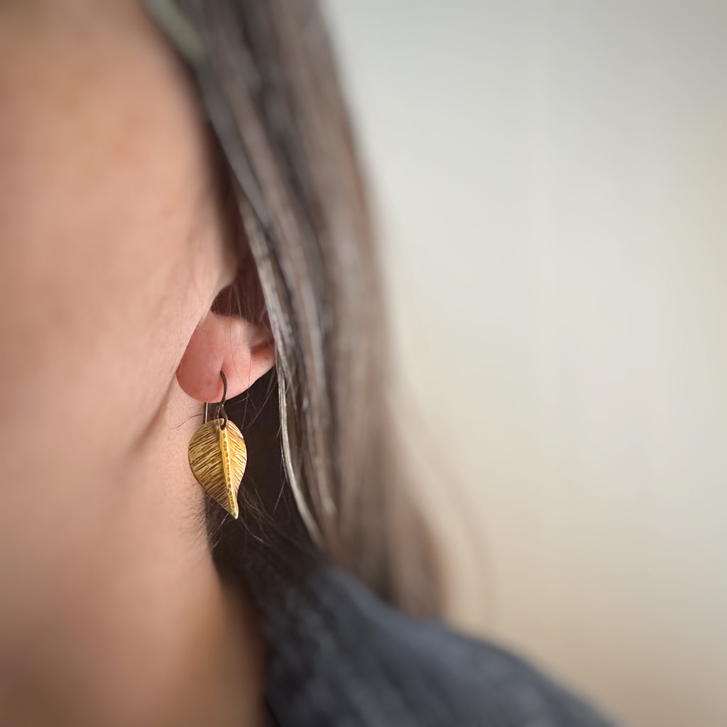medium earrings that are hand formed and hammer textured leaves made of oxidized brass