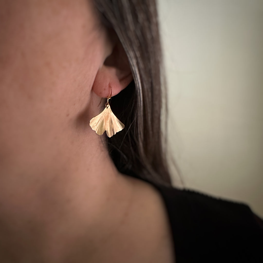 Medium 14k gold filled ginkgo leaf earrings shown on model.