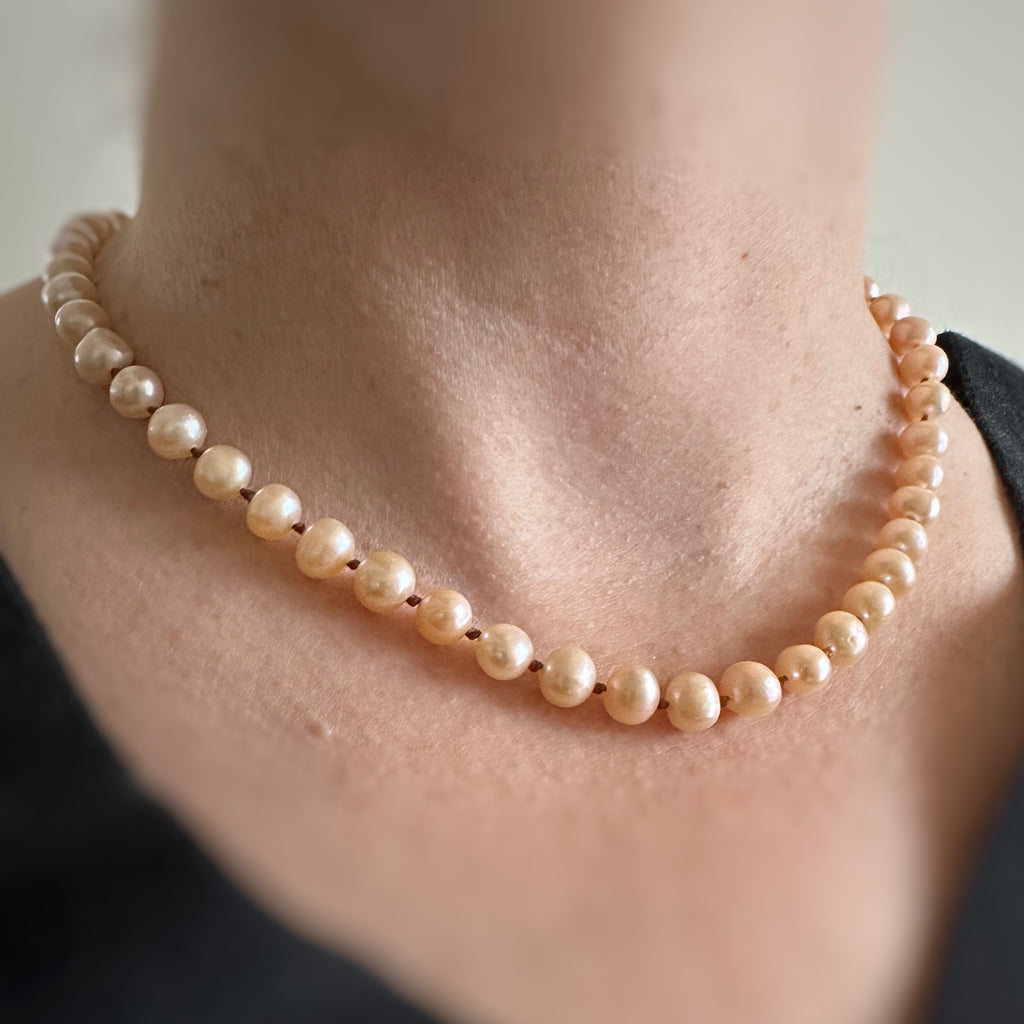 hand knotted peach freshwater peal necklace on model
