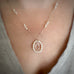 Teardrop pendant made with white pearls and clear crystal on a person's neck