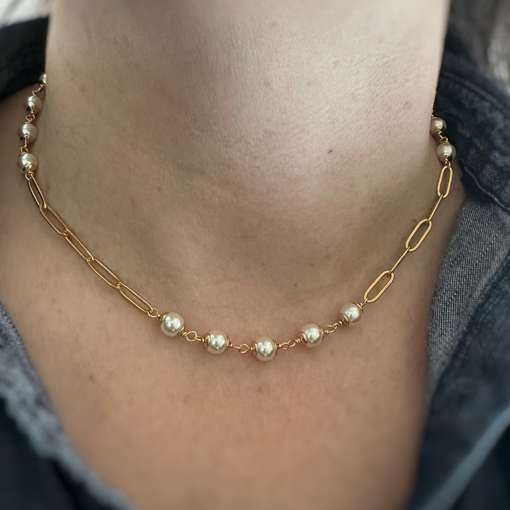 6mm white crystal pearls linked in groups of five interspersed within a gold tone paperclip style chain. Shown as worn.