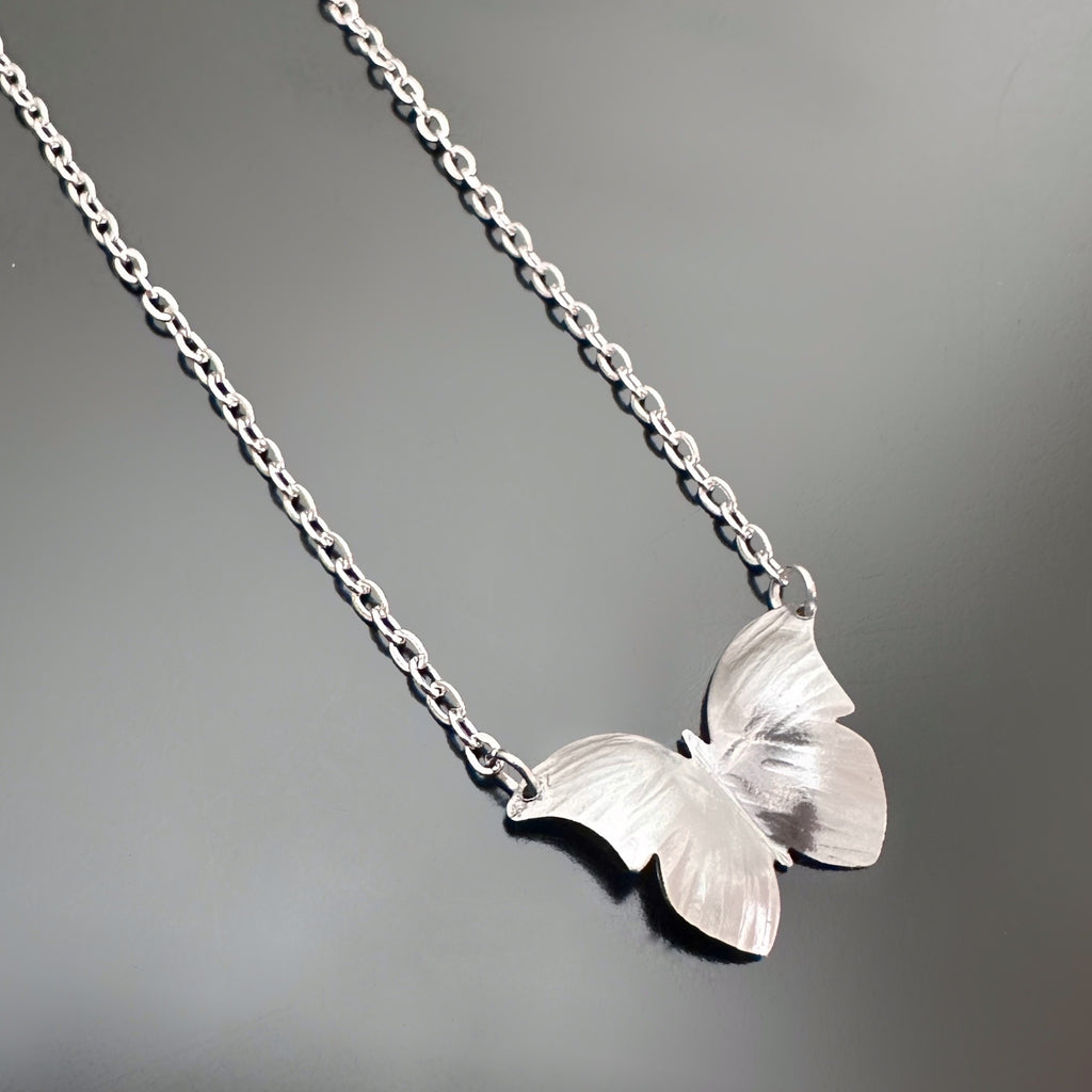 silver tone surgical steel butterfly pendant with hammered details in the wings, on a dainty chain