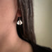 Small sterling silver ginkgo leaf earrings on model.