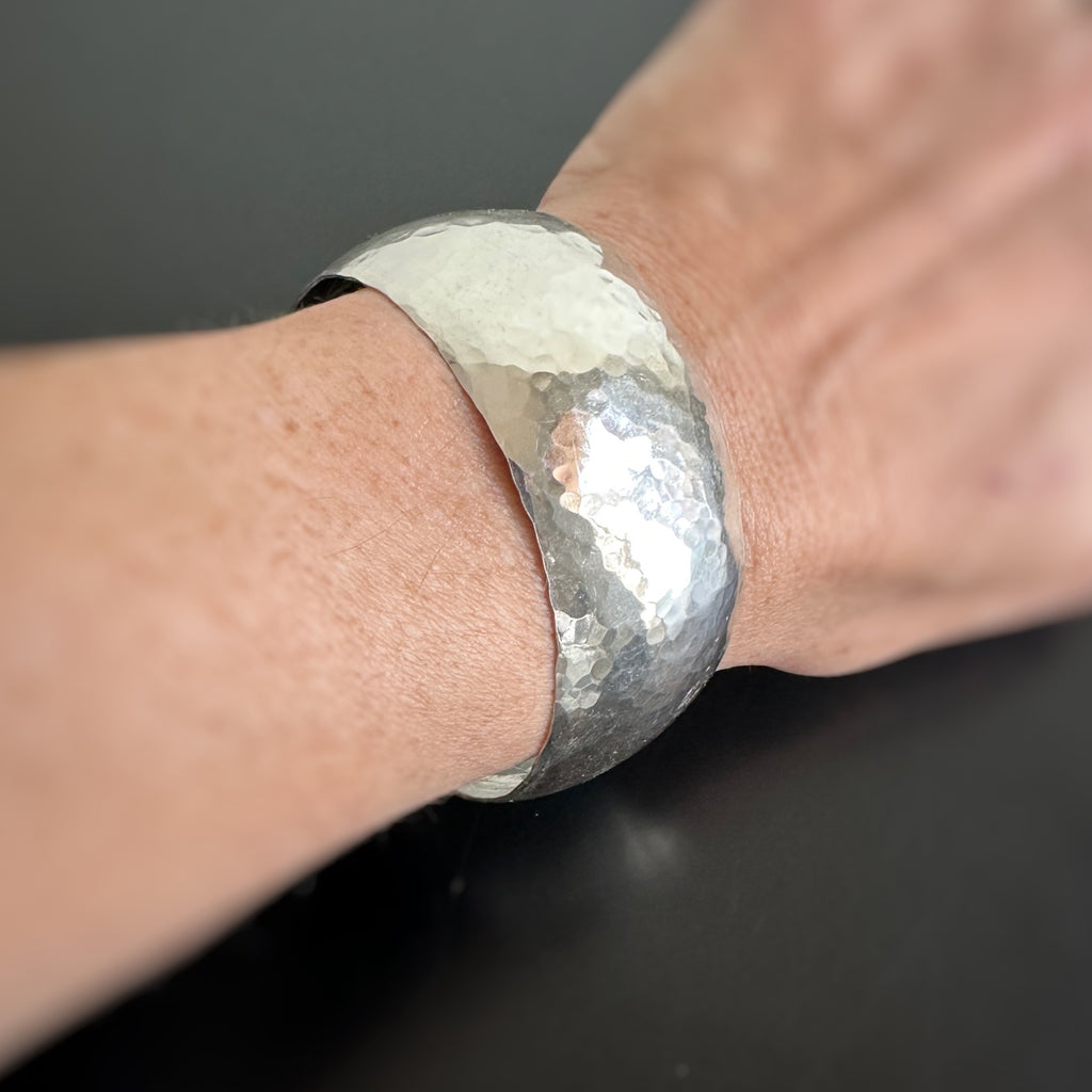 hand made sterling silver wide 1" cuff bracelet with domed shape and hammered texture.