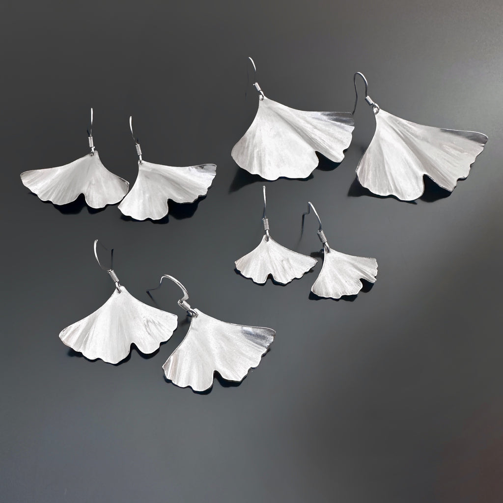 surgical grade stainless steel handmade ginkgo leaf earrings in four different sizes.