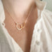 Gold-filled and sterling silver interlocking teardrops necklace worn by a person in a white shirt.