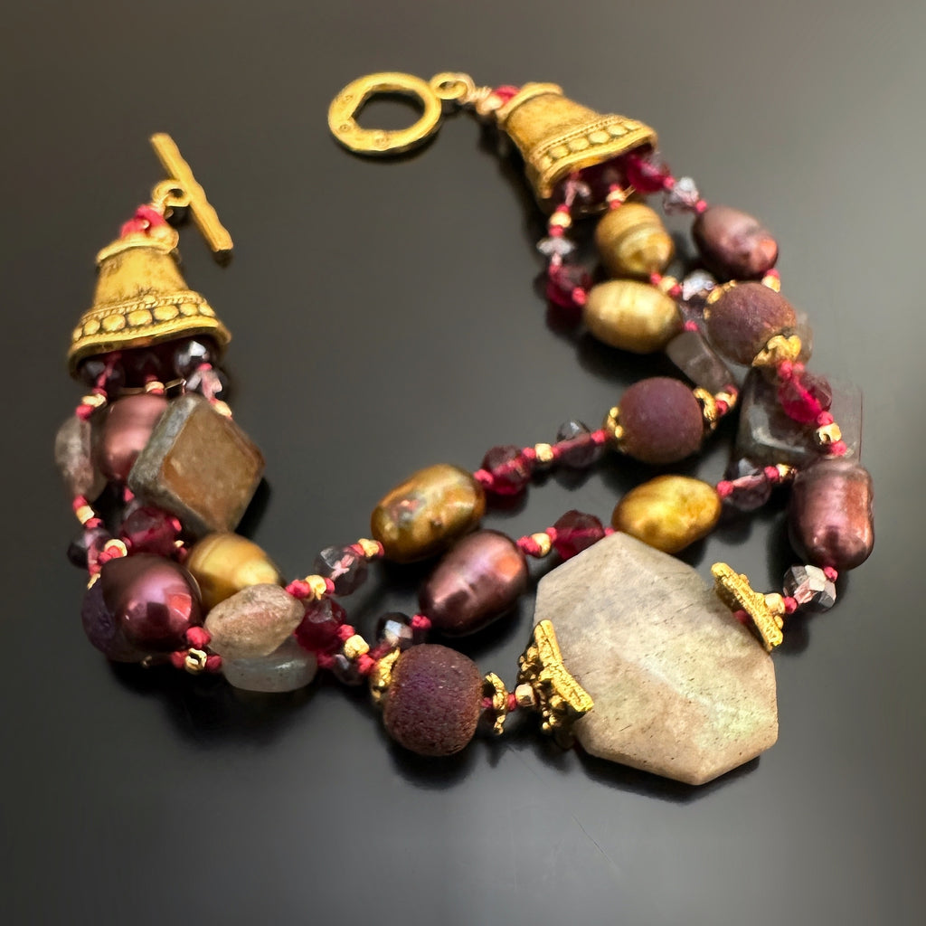 hand-knotted- three strand bracelet with wine colored freshwater pearls, garnet colored glass, and labradorite and golden accents.