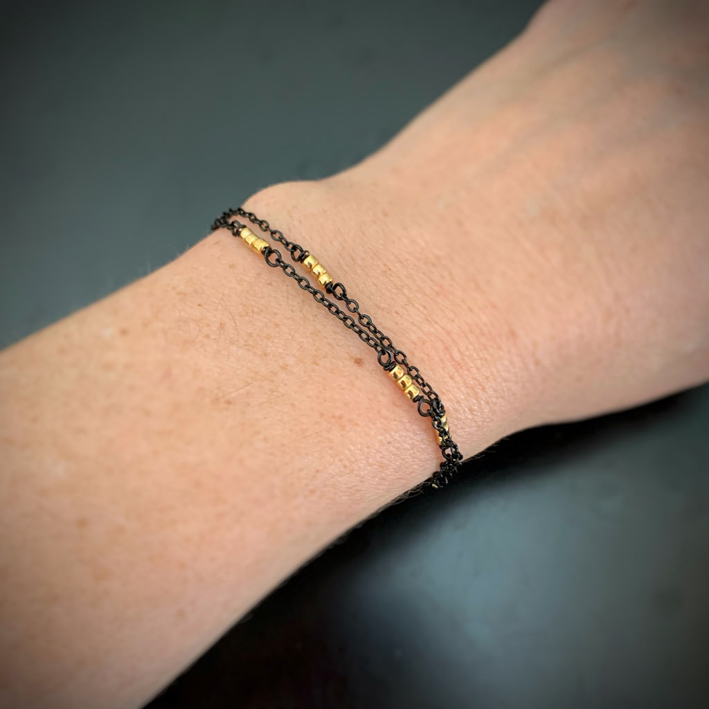 two strand bracelet with black chain and gold beads