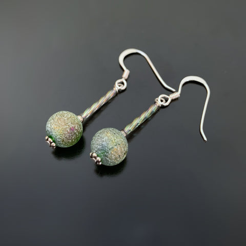 sterling silver drop earrings with twisted columns and ancient looking green glass