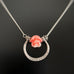 Handmade sterling silver horseshoe shaped pendant with carved rose bead in a peachy pink coral color.