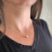 Pewter colored freshwater pearl pendant that slides on a sterling silver necklace, shown on model.