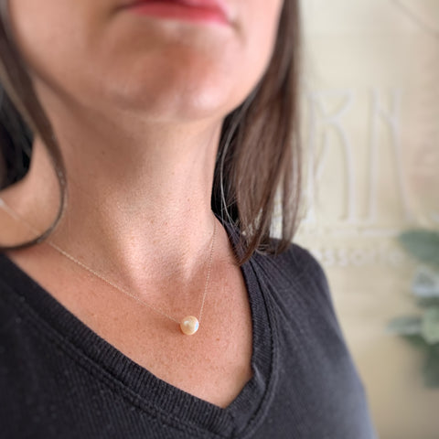 Simple sliding white freshwater pearl on sterling silver chain necklace, shown on model.