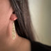 14k gold-filled teardrop earrings with stamped ginkgo leaves on model.