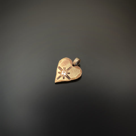 brass heart pendant with starburst and a white sapphire