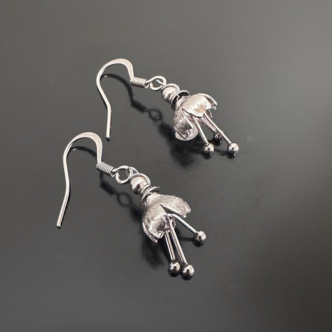 Hand made and scuplted surgical grade steel inverted flower with a satin finish with  long dangling stamen.