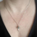 Hand made and scuplted surgical grade steel flower with a satin finish. The pendant hangs from a delicate chain. Shown on model.