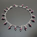 faceted cube shaped garnet beads dangling from a paper clip style silver tone chain.