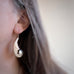 Statement earrings made of vintage silverplate in an engraved scrollwork style and hang from a french hook style 304 grade surgical steel ear wire.  Shown on model.