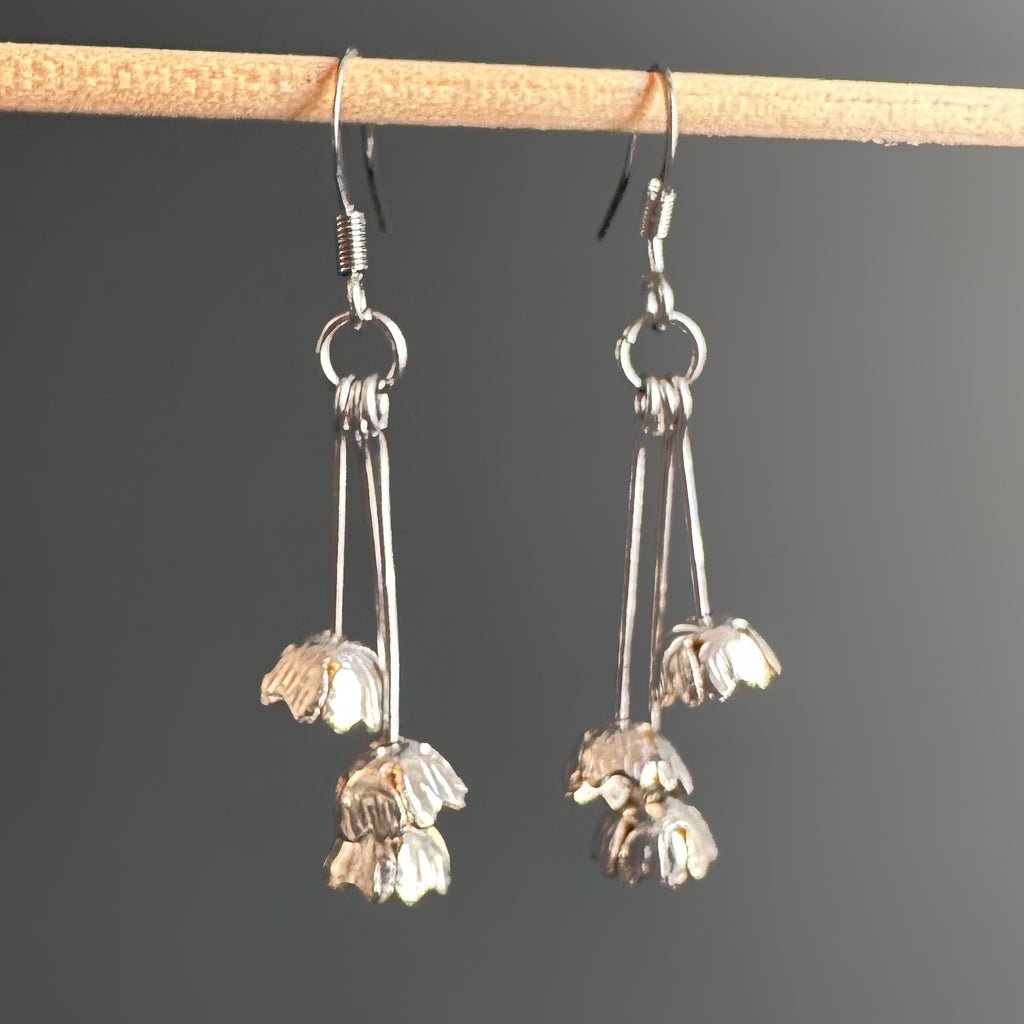 Three tiny bell shaped flowers made from vintage silverplate, each on separate stems and hanging in a cluster from french hook style ear wire.