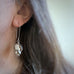 Long statement earrings handmade from vintage silverplate and designed to emulate the image of hops flowers. They have a long shepherd hook style ear wire. Shown on model.