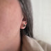Handmade brass flowers with small round garnets set in the center. Surgical steel post earrings, shown on model.