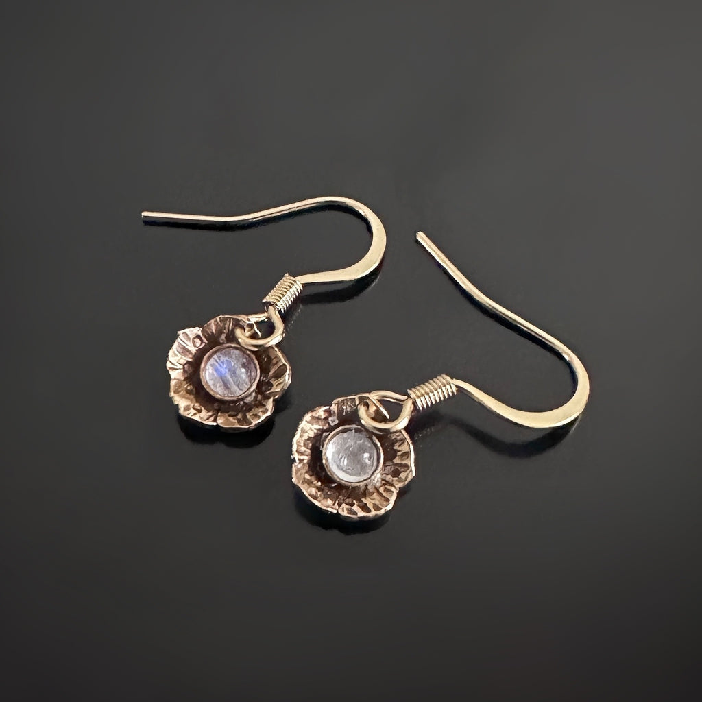 Tiny golden flower shape dangle earrings with moonstones set in the middle of each flower.