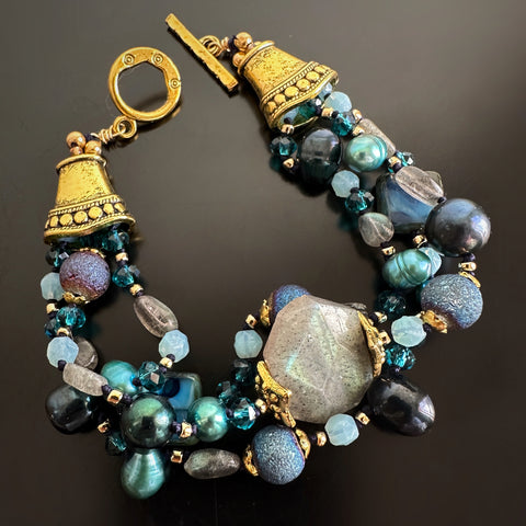 three-strand hand-knotted bracelet in blue hues made with labradorite, freshwater pearls, glass and golden accents.