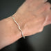 sterling silver curly bracket parenthesis bangle bracelet on model.