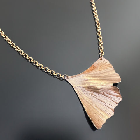 Golden oxidized brass necklace with a ginkgo leaf shaped pendant on a heavy rolo style chain