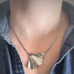 Silver surgical steel rolo chain necklace with a ginkgo leaf pendant worn by a person.