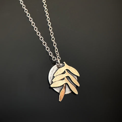 golden brass fern leaf design on a sterling silver pendant with chain