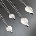 Silver toned surgical steel leaf necklaces on a delicate chain, showing 4 different size  options