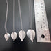 silvery surgical steel leaf pendants shown next to ruler to illustrate the fur size options, .75", .90", 1", and 1.25".