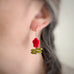 Leafy flower earrings in red on model.