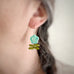 Leafy flower earrings in sea green on model.
