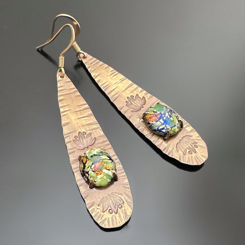 long brass teardrop earrings with french hook ear wires.  The tear drop has hammer marks and stamped lotus flowers with a focal of a green opal glass oval, prong-set near the bottom.