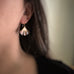 Medium oxidized brass ginkgo leaf earrings shown on model.
