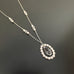 Sterling silver with a pendant featuring a beaded teardrop of white pearls and a clear teardrop crystal.  The chain has pearls and crystal interspersed within.