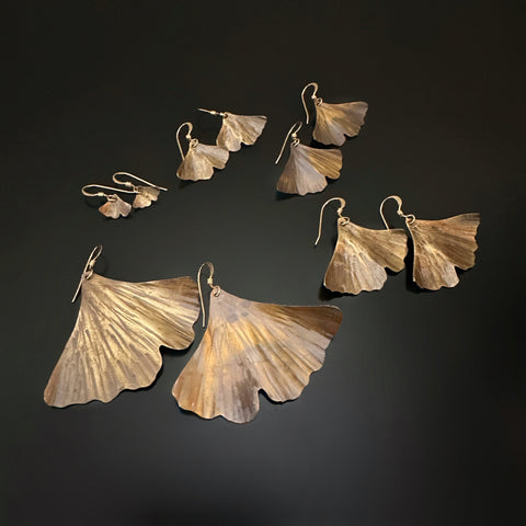 Oxidized brass ginkgo leaf earrings in five different sizes.