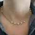 6mm white crystal pearls linked in groups of five interspersed within a gold tone paperclip style chain. Shown as worn.