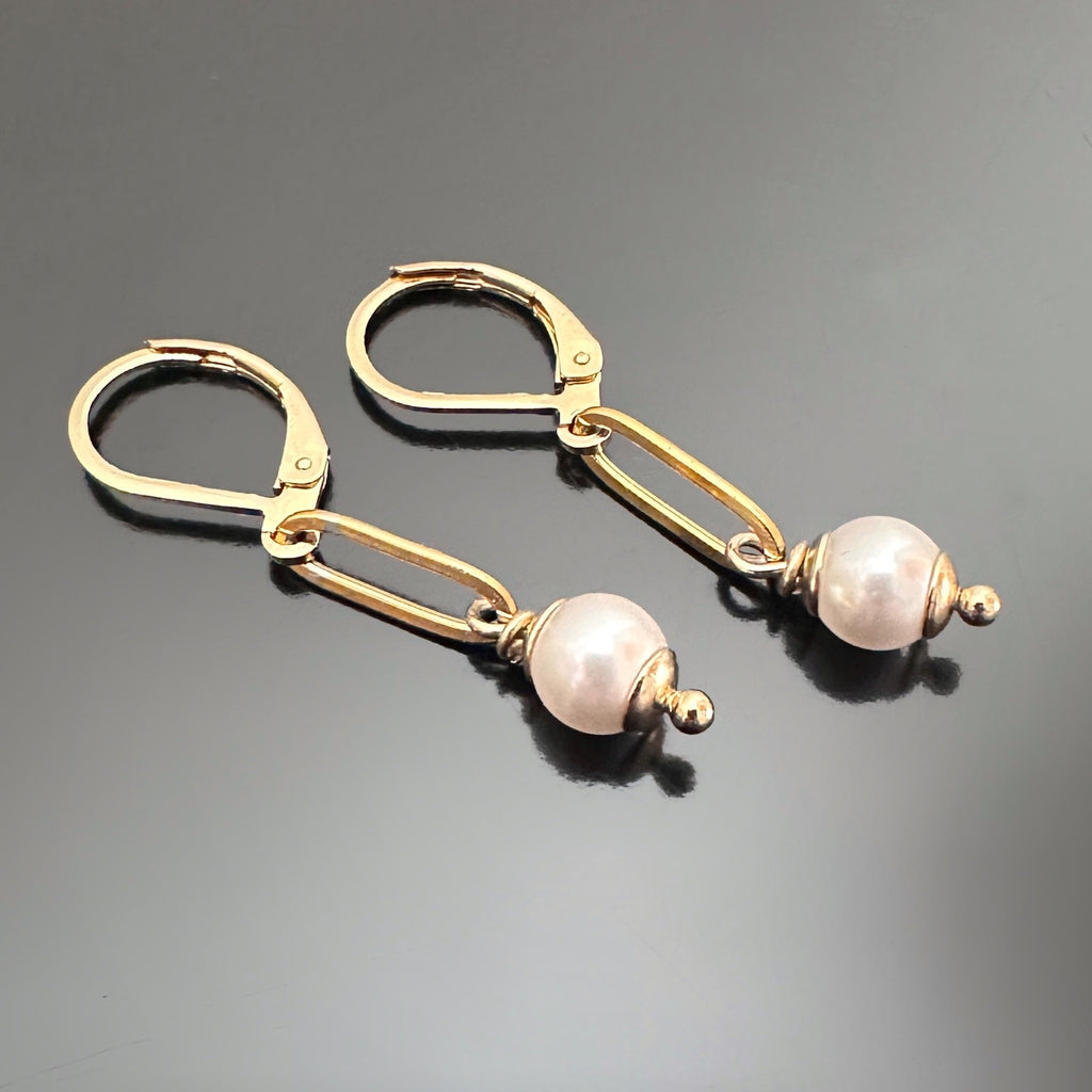 Dangle earrings with a 6mm white crystal pearl dropping from a single link of gold tone paperclip style chain.  The earrings are a leverback style.