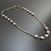 6mm white crystal pearls linked in groups of five interspersed within a gold tone paperclip style chain.
