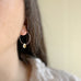 handmade sterling silver hoop earrings with a small clear ab iridescent Austrian crystal teardrop dangle.