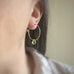 handmade sterling silver hoop earrings with a small peridot green Austrian crystal teardrop dangle.