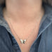 silver tone surgical steel butterfly pendant with hammered details in the wings, on a dainty chain. shown as worn.